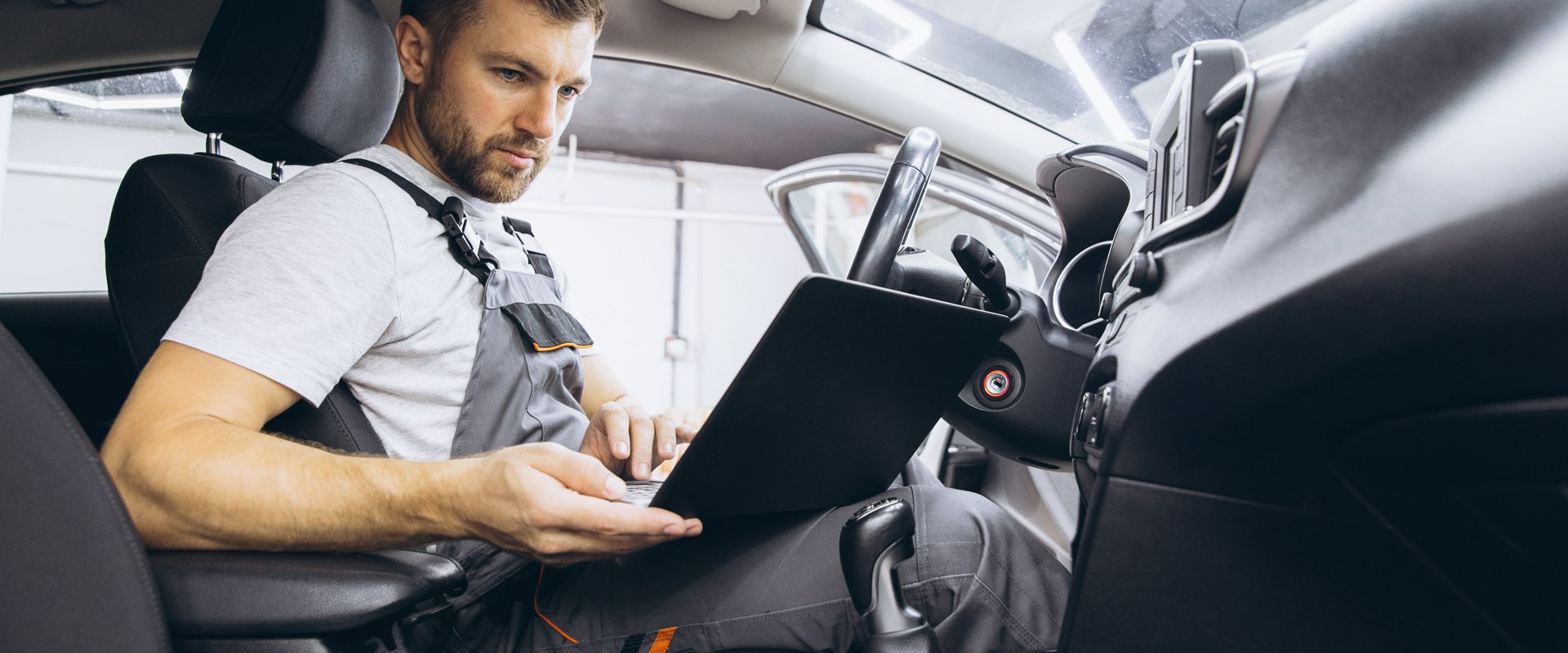 mechanik w aucie z laptopem