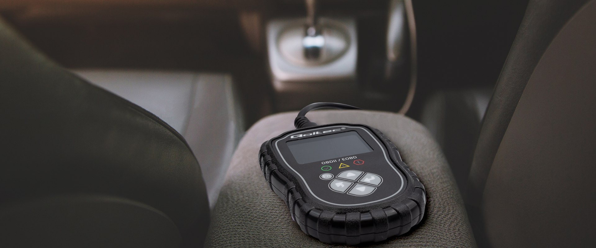 Tester leżący na podłokietniku miedzy przednimi siedzeniami w samochodzie